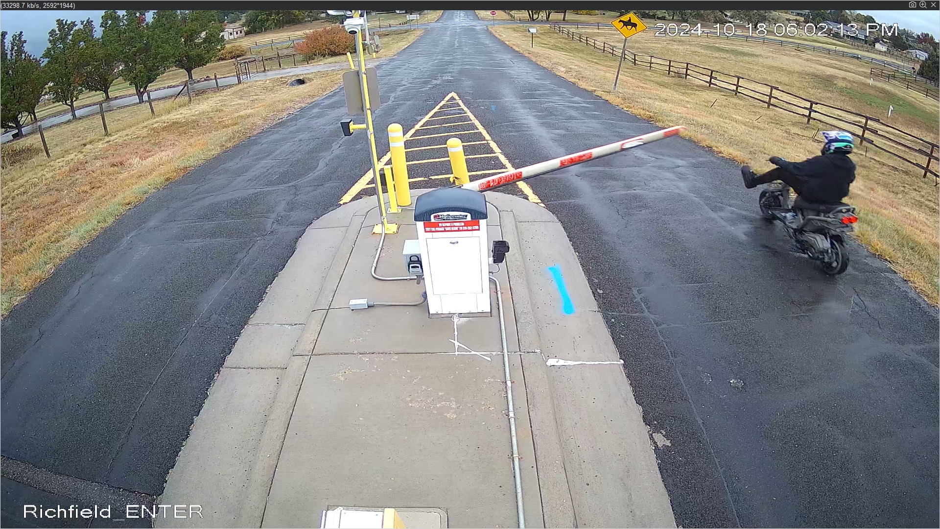 Person on scooter kicking gate 